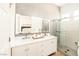 Modern bathroom with a double vanity, illuminated mirror, and a glass-enclosed shower with light gray tiling at 10301 Coal Creek Pl, Las Vegas, NV 89134