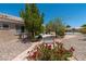 Tranquil side yard featuring desert landscaping, a bench, and decorative red flowers at 10301 Coal Creek Pl, Las Vegas, NV 89134