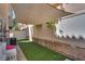 Private backyard featuring artificial grass, with a sun-blocking canvas and privacy fence at 10519 Mann St, Las Vegas, NV 89141
