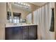 Bathroom featuring double sinks, a large mirror, and a shower/tub with a curtain at 10519 Mann St, Las Vegas, NV 89141