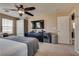 Comfortable bedroom featuring neutral walls and carpet has a ceiling fan and TV at 10519 Mann St, Las Vegas, NV 89141