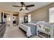 Bright bedroom featuring neutral walls and carpet has a ceiling fan and ensuite bathroom access at 10519 Mann St, Las Vegas, NV 89141