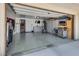Garage featuring epoxy floors, storage cabinets, and a TV at 10519 Mann St, Las Vegas, NV 89141