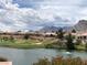Scenic view of a golf course with a pond, lush landscaping, and houses against a mountain backdrop at 10832 Heritage Hills Dr, Las Vegas, NV 89134
