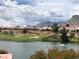 Picturesque view of a golf course with a pond, desert landscaping, and houses against a mountain backdrop at 10832 Heritage Hills Dr, Las Vegas, NV 89134