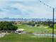 Scenic golf course view with lush green fairways, palm trees, and mountain backdrop, captured from a balcony at 10832 Heritage Hills Dr, Las Vegas, NV 89134