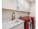 Well-equipped laundry area boasts sink, counter space, and modern red washer and dryer for convenient chores at 11280 Granite Ridge Dr # 1012, Las Vegas, NV 89135