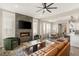 Open-concept living room with stone fireplace, flatscreen TV, and modern furnishings, seamlessly flowing into the dining area at 11280 Granite Ridge Dr # 1012, Las Vegas, NV 89135