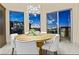 Light-filled dining area features modern chandelier, dining table with seating, and views of outdoor grill at 1228 Stellar Rim Ct, Henderson, NV 89012