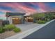 Contemporary home featuring multi-car garage, desert landscaping, and stone accents against a vibrant twilight sky at 1228 Stellar Rim Ct, Henderson, NV 89012