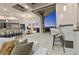 Open-concept living space with bar seating, dining area, kitchen, and floor-to-ceiling doors to outside pool at 1228 Stellar Rim Ct, Henderson, NV 89012