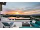 Relax in comfort on this tile patio with a zero edge pool, lounge chairs, and a conversation set overlooking city views at 1228 Stellar Rim Ct, Henderson, NV 89012