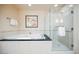 Bright bathroom with a shower featuring glass doors and a soaking tub with a dark countertop at 135 Harmon Ave # 3220, Las Vegas, NV 89109