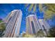 Striking exterior shot of a modern high-rise building with palm trees and blue skies at 135 Harmon Ave # 3220, Las Vegas, NV 89109