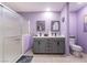 Well-lit bathroom featuring a double vanity, toilet, and large glass-enclosed shower at 162 Sand Lake St, Henderson, NV 89074