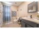 Cozy bathroom featuring a grey vanity, toilet, shower with a curtain, and a large window at 162 Sand Lake St, Henderson, NV 89074