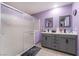 Well-lit bathroom with double vanity, grey cabinetry, and a glass-enclosed shower at 162 Sand Lake St, Henderson, NV 89074