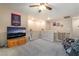 Open bonus room with neutral carpet, fan, TV, and stair access at 162 Sand Lake St, Henderson, NV 89074