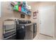 A laundry room featuring tile floors, washer and dryer, wire shelving, and a white door at 162 Sand Lake St, Henderson, NV 89074