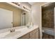 Bathroom featuring a double sink vanity, large mirror, and a peek at the tiled shower and tub at 1620 Yellow Rose St, Las Vegas, NV 89108