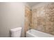 Bathroom featuring a tiled tub and shower, alongside a standard toilet at 1620 Yellow Rose St, Las Vegas, NV 89108