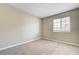 A carpeted bedroom featuring a window, base trim, neutral paint, and white outlets at 1620 Yellow Rose St, Las Vegas, NV 89108