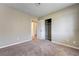Spacious bedroom with plush carpeting, closet, white trim, neutral walls and doorway to another room at 1620 Yellow Rose St, Las Vegas, NV 89108