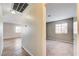 Hallway with neutral paint leads to a carpeted bedroom, and another room with light wood-look flooring at 1620 Yellow Rose St, Las Vegas, NV 89108