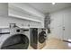Laundry room features modern washer/dryer, shelving, and tile floors at 1620 Yellow Rose St, Las Vegas, NV 89108