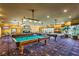 Inviting billiards room with multiple tables, cozy lighting, and a stone fireplace at 170 Wicked Wedge Way, Las Vegas, NV 89148