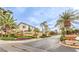Inviting Travina community entrance with lush landscaping, flowers, and palm trees at 170 Wicked Wedge Way, Las Vegas, NV 89148