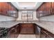 Kitchen with dark wood cabinets, granite countertops, stainless sink, and tiled flooring at 1729 Yellow Rose St, Las Vegas, NV 89108