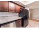 Kitchen area with granite counters, black appliances, wood cabinets, and hardwood flooring at 1729 Yellow Rose St, Las Vegas, NV 89108