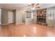 Spacious living room featuring hardwood floors, a stone fireplace, and a ceiling fan at 1729 Yellow Rose St, Las Vegas, NV 89108