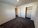 A carpeted bedroom has two closets, an open door to a hallway, and neutral walls at 1906 Arietta Vista St, Henderson, NV 89044