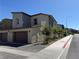 A modern two-story townhouse shows two garages and a well-maintained yard with trees at 1906 Arietta Vista St, Henderson, NV 89044