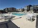 Community pool with tables and lounge chairs surrounded by neighborhood townhomes on a sunny day at 1906 Arietta Vista St, Henderson, NV 89044