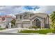 Two-story home with stone and gray stucco featuring a three-car garage, and landscaped front yard at 2959 Azure Bay St, Las Vegas, NV 89117