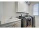 Functional laundry room with white cabinets, sink, and modern appliances at 2959 Azure Bay St, Las Vegas, NV 89117