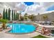 Gorgeous pool with a spa, lounge chairs, and lush landscaping offers a perfect escape at 2959 Azure Bay St, Las Vegas, NV 89117