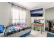 Bright bedroom with television, desk, window, closet, and light gray walls at 3145 Tarpon Dr, Las Vegas, NV 89120