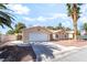 Single-story home showcasing a well-maintained yard, complemented by mature palm trees and attached two-car garage at 3145 Tarpon Dr, Las Vegas, NV 89120