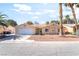 Inviting single-story home, featuring desert landscaping, two-car garage, and palm trees, under a sunny sky at 3145 Tarpon Dr, Las Vegas, NV 89120