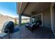 Spacious backyard featuring a covered patio, seating area, artificial grass, and BBQ grill at 32 Via Del Fiume, Henderson, NV 89011