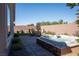Beautiful backyard features a brick patio, hot tub, artificial grass, and outdoor seating at 32 Via Del Fiume, Henderson, NV 89011