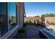 Beautiful backyard features a brick patio, hot tub, artificial grass, and outdoor seating at 32 Via Del Fiume, Henderson, NV 89011