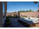 Beautiful backyard features a brick patio, hot tub, artificial grass, and outdoor seating at 32 Via Del Fiume, Henderson, NV 89011
