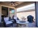 Relaxing covered patio featuring comfortable seating, a fire pit, and a built-in grill at 32 Via Del Fiume, Henderson, NV 89011