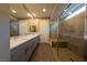Bathroom with double vanity, quartz countertop, tile flooring, large mirror, and large glass enclosed shower with tile surround at 32 Via Del Fiume, Henderson, NV 89011