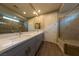 Bathroom with double vanity, quartz countertop, tile flooring, large mirror, and large glass enclosed shower with tile surround at 32 Via Del Fiume, Henderson, NV 89011